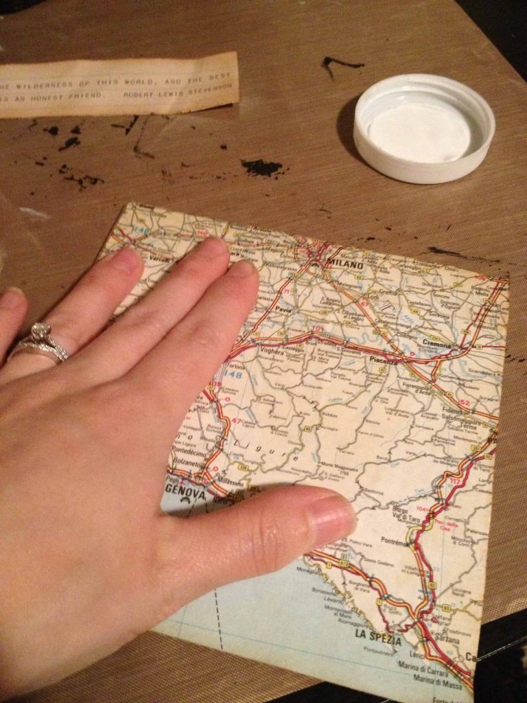 Place the vintage map cutout onto the shadowbox background coated with mod podge. Use your hand to gently smooth out the paper.