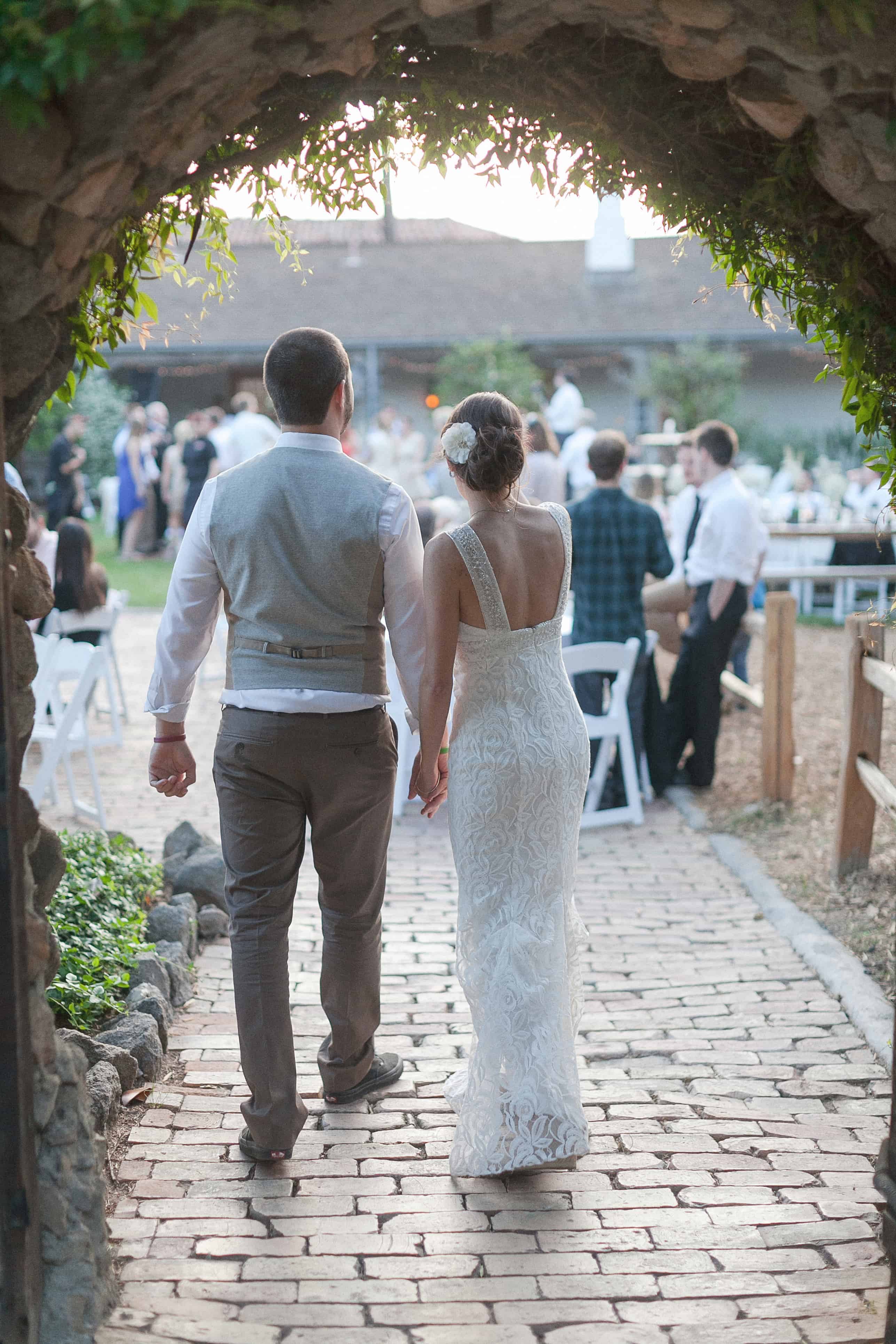 bride and groom in reception holding hands