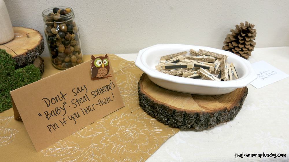 mason jars full of acorns and neutral table clothes. white plate with woods, wood round and table card with printed owl that says Don't say 