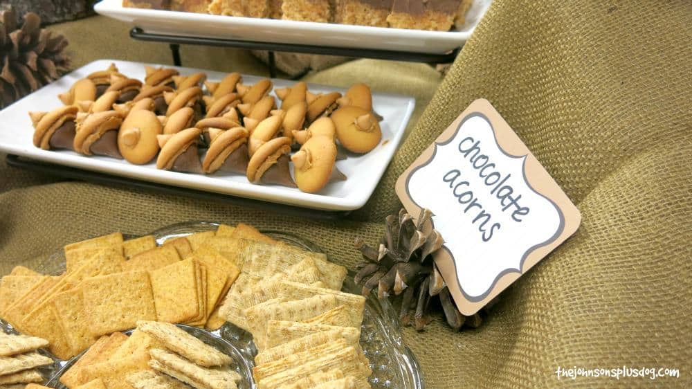 Chocolate Acorns made with Hersey's kiss, peanut butter and nilla wafer beside the menu place card that says chocolate acorns and crackers for Forest Themed Shower