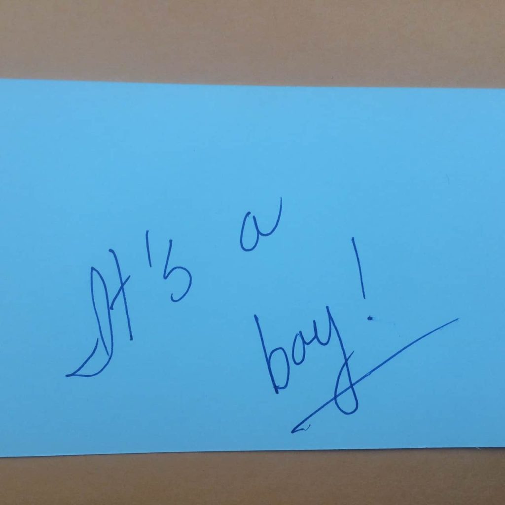 It's a boy! written blue index card to announce the gender