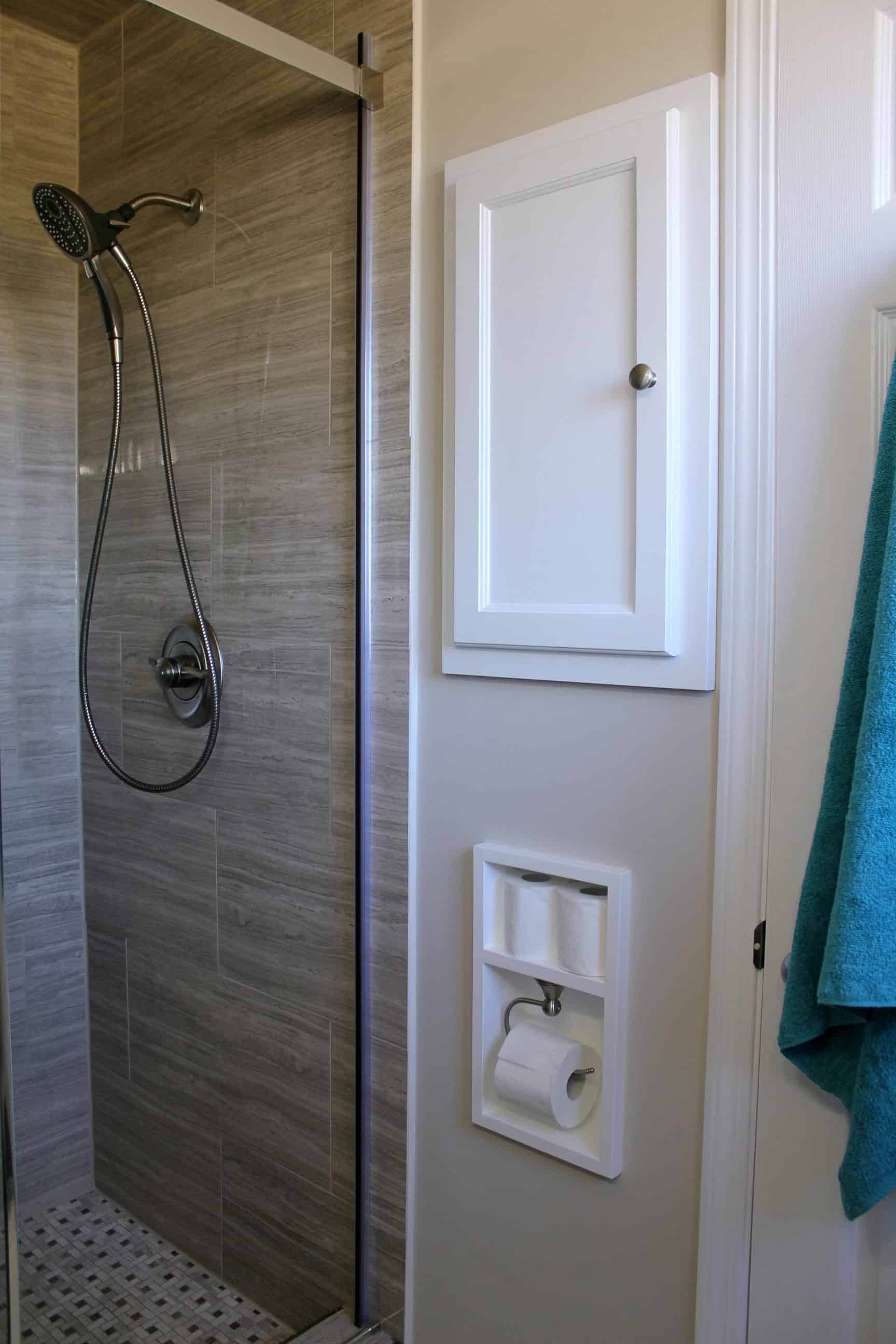 Use the space in between the studs in your wall to install a recessed medicine cabinet and toilet paper holder with shelf for extra toilet paper rolls 