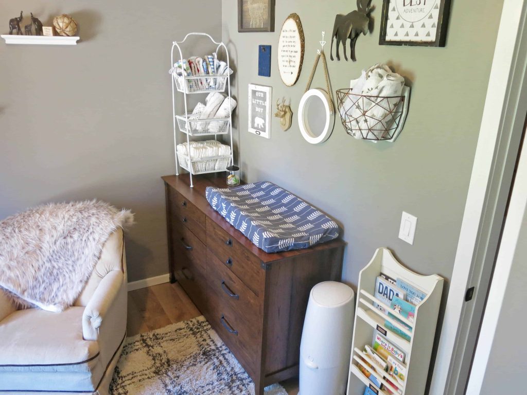 a view of a changing table in the corner of a home nursery with rustic decor