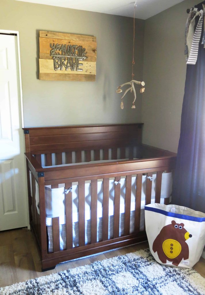 a wooden crib with a metal sign above it that says 