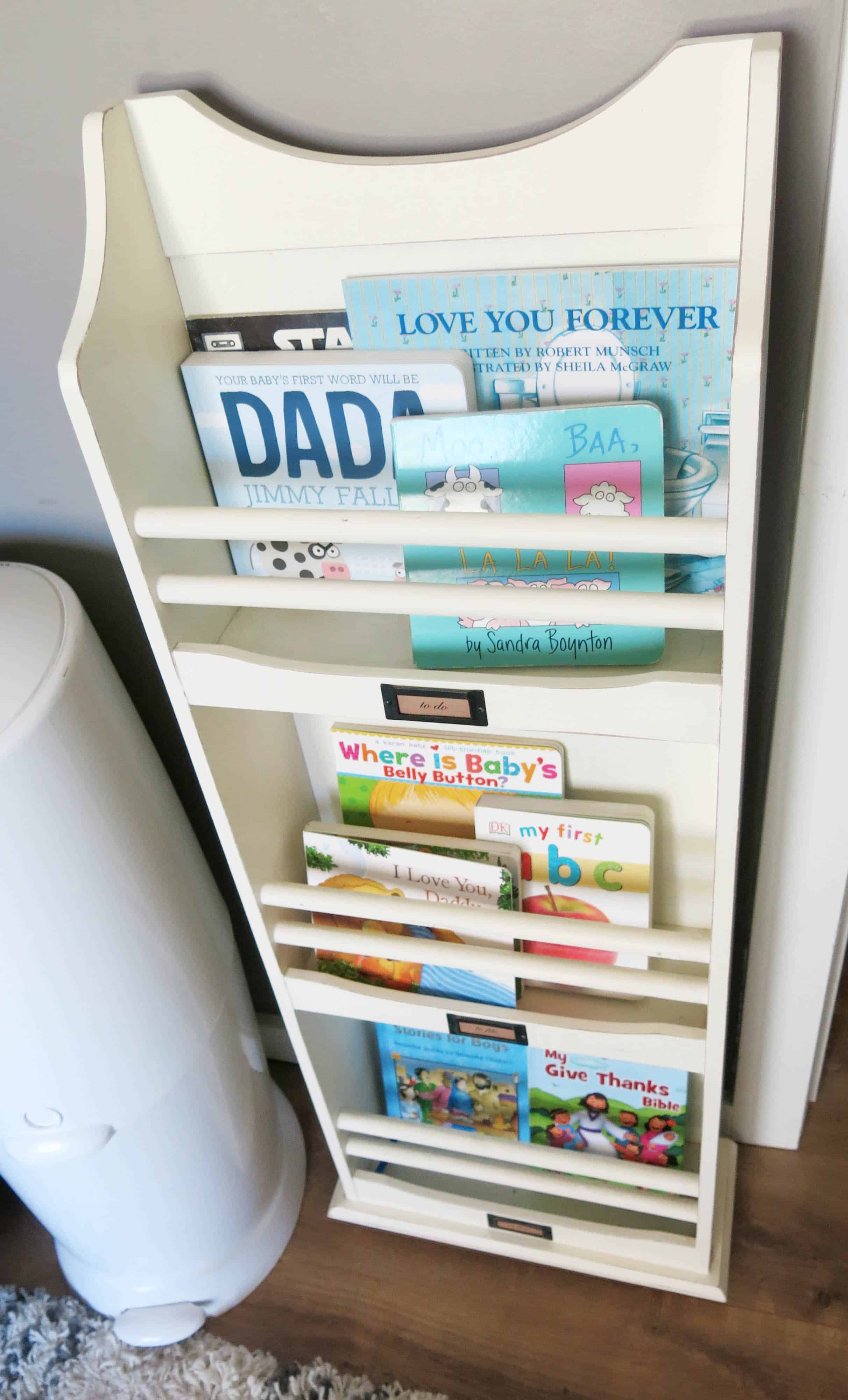 magazine rack filled with children's books in rustic woodland nursery