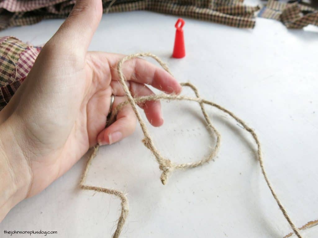 Looping jute twine together to make the hanger for our homemade fabric ornaments.