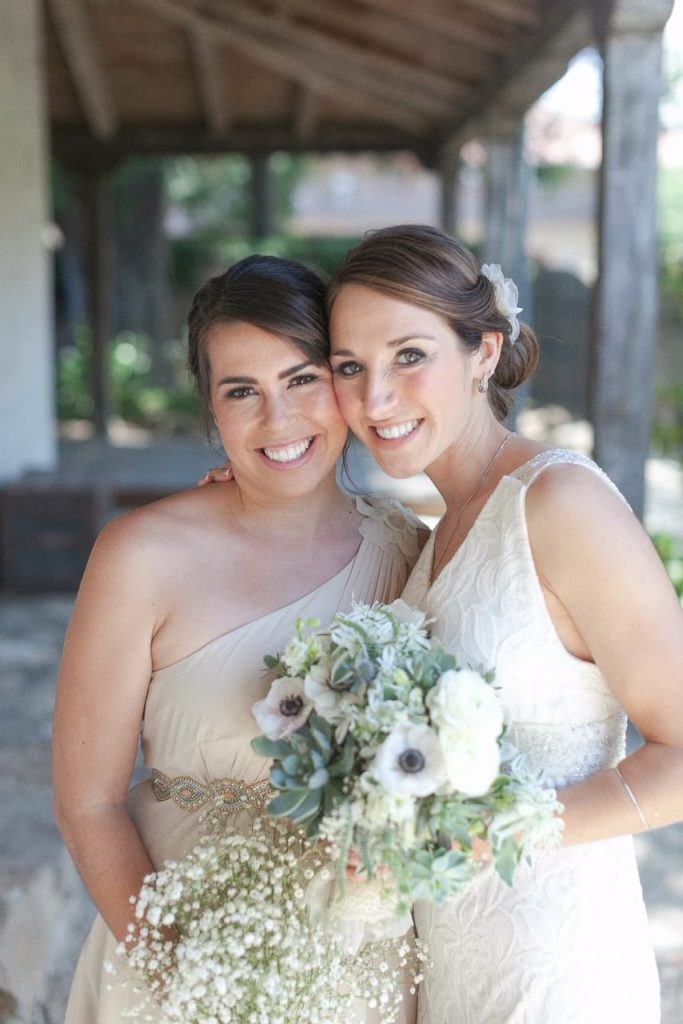 bride with maid of honor at outdoor wedding holding bouquets