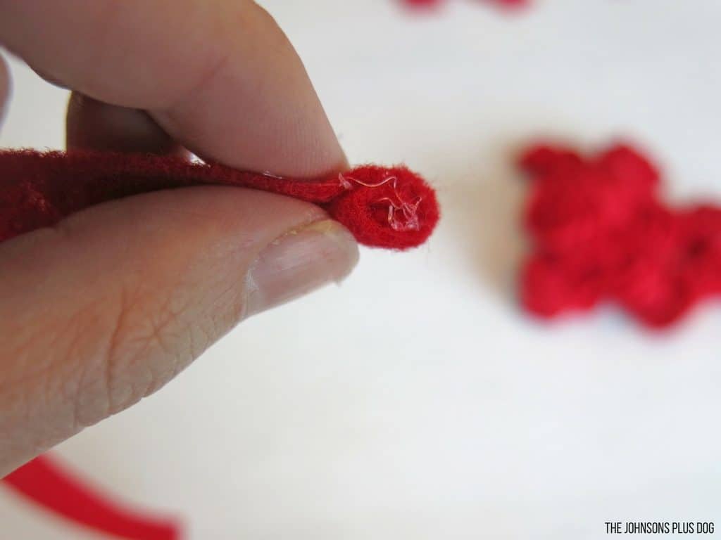 Woman hand rolling the red felt strip