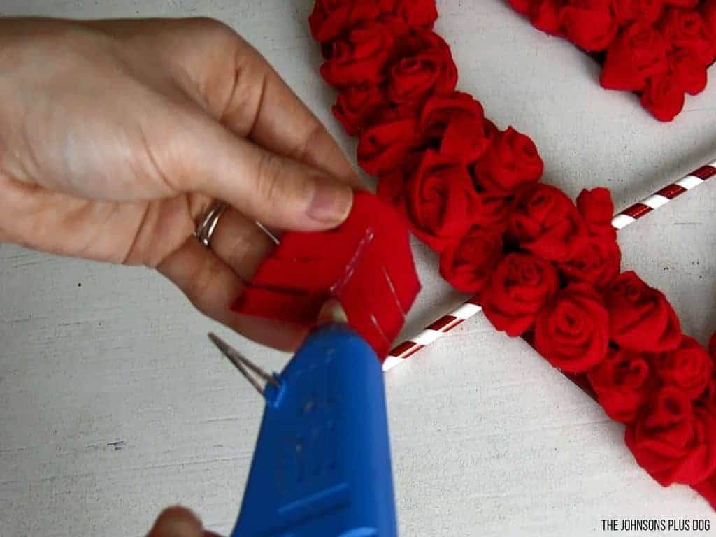 Woman holding a glue gun sticking the arrow end