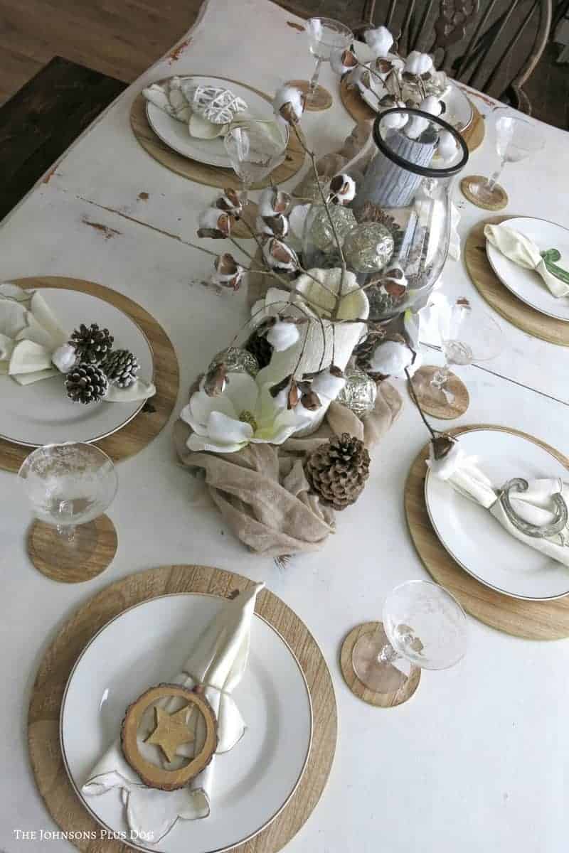 This winter tablescape is made with faux cotton stems in vases and rustic place settings