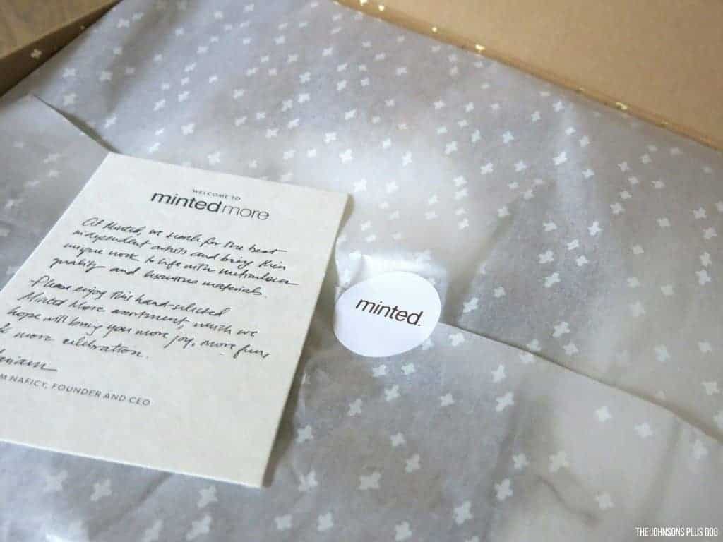 The tissue wrapped contents of a Minted More membership box, and a welcome note from Minted More.