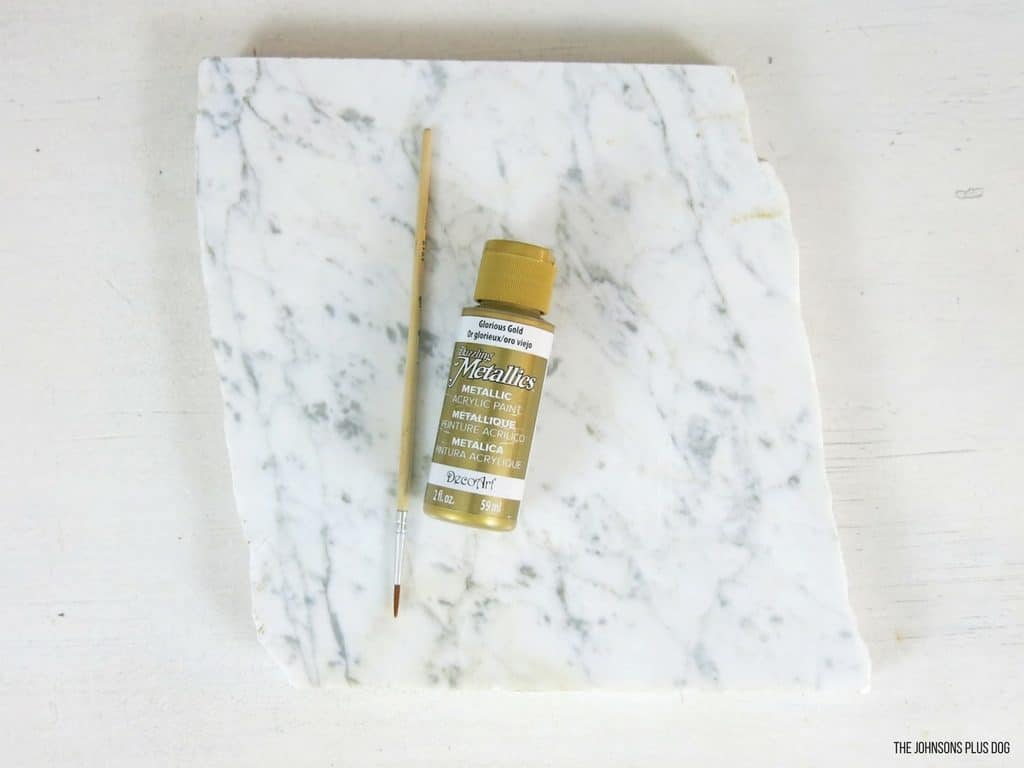 Supplies needed to make this painted marble glam office decor: gold acrylic paint, a thin-line paint brush, and a piece of marble slate