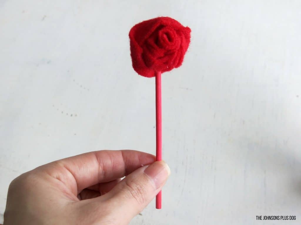 A cute DIY felt rosette on a red stick