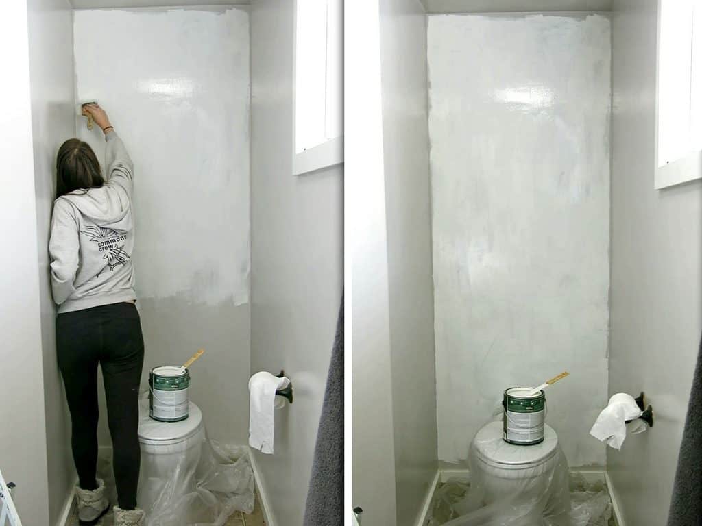 Painting the grey walls of the toilet nook with white primer paint.