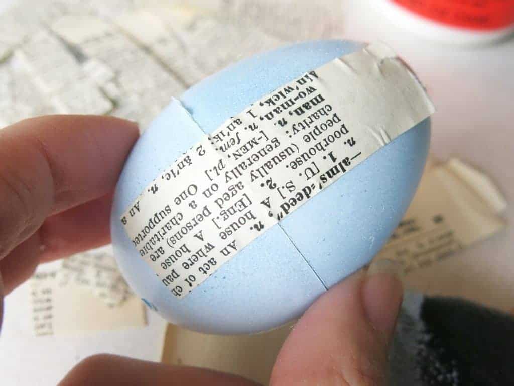 Use mod podge to attach the vintage book pages to the plastic Easter egg