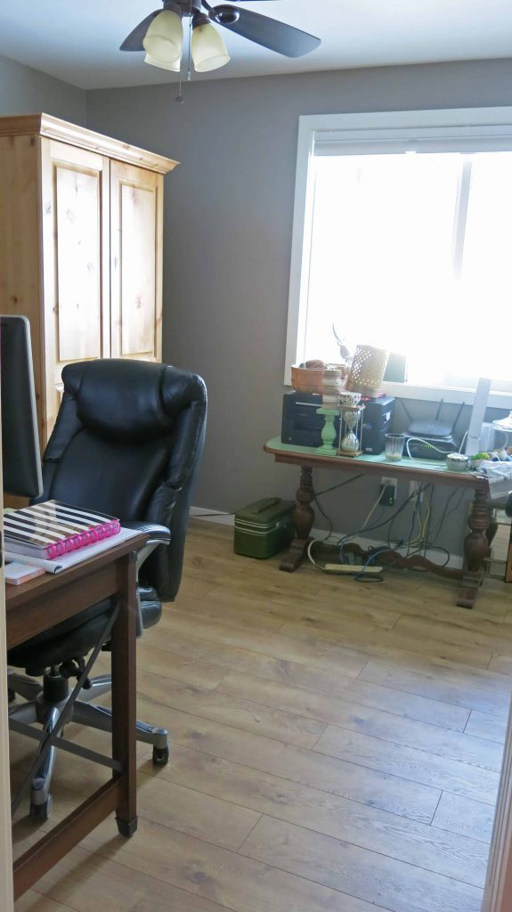 A cluttered table in the home office before the fun marble and gold office makeover