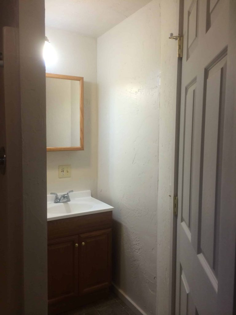 The view inside our master bathroom, before it's farmhouse makeover. The door opened up to see the sink vanity and the shower.