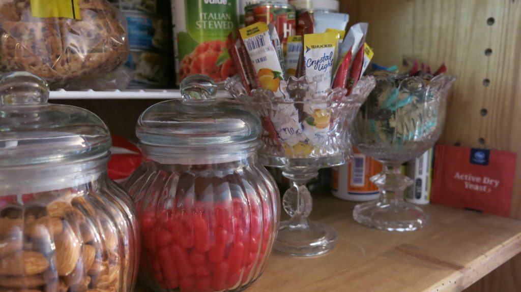 Glass jars for pantry organization filled with Hot Tamales, almonds and packets of lemonade