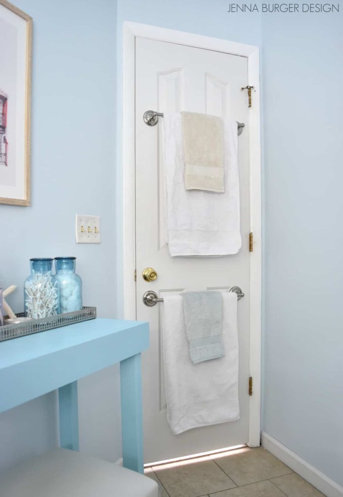 Take advantage of your bathroom door by adding your towel bars to that back of it 