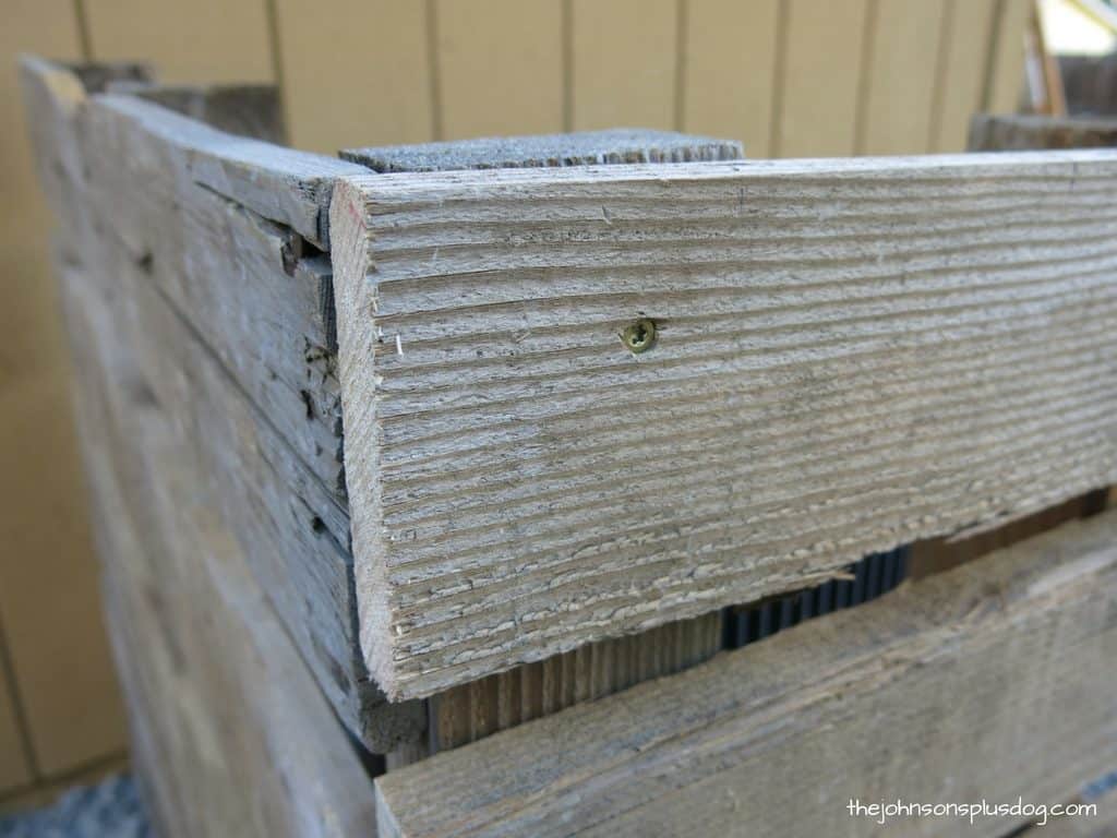 A close up look at the joints of the pallet wood AC unit cover, where screws hold the wooden bars to the wood posts.