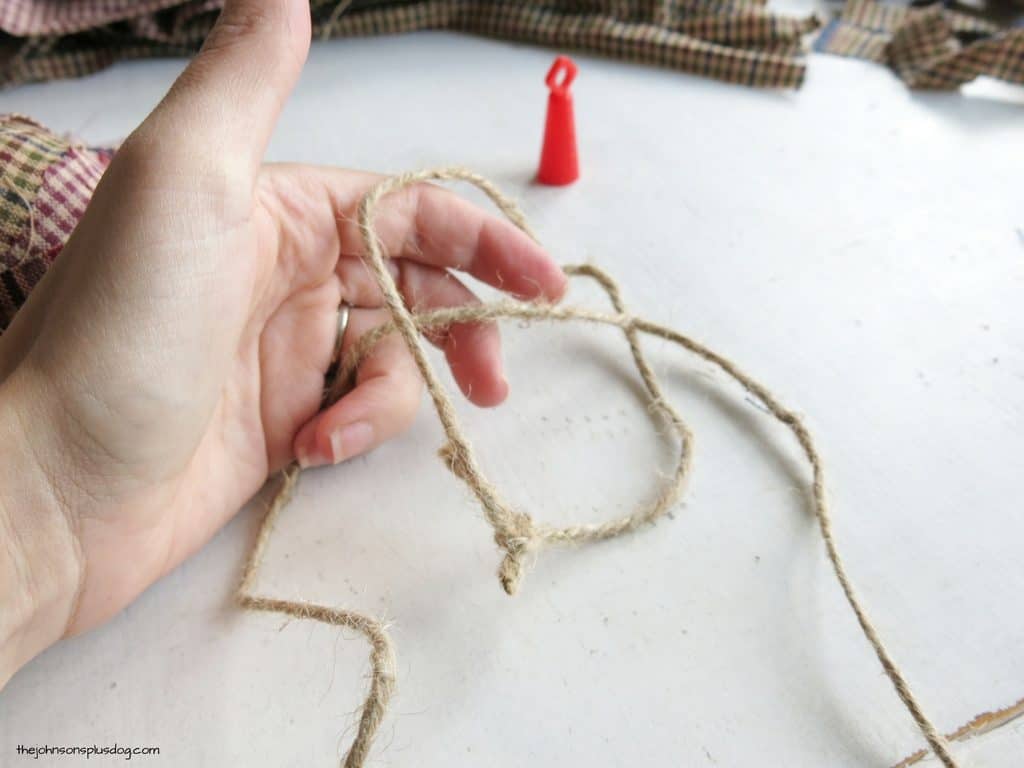 Creating the hanging string for our homemade fabric ornaments from jute twine.