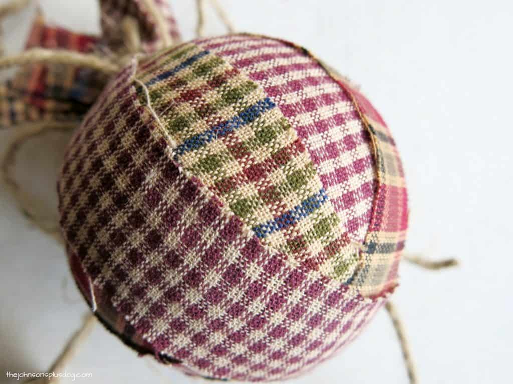 A close up look at the homemade fabric ornament made with strips of homespun plaid fabric.