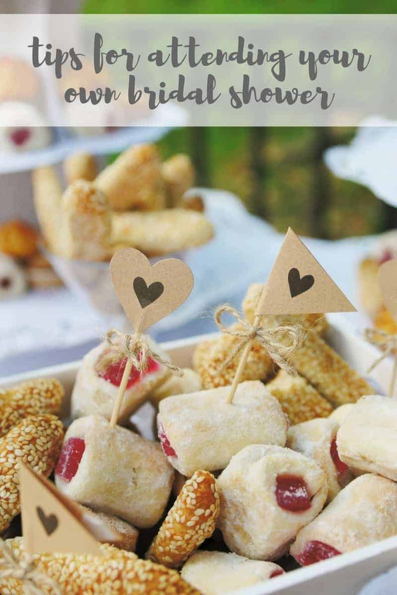 Bite sized cookies and pretzel bites with little paper flag sticks on a platter. Image text reads "tips for attending your own bridal shower"