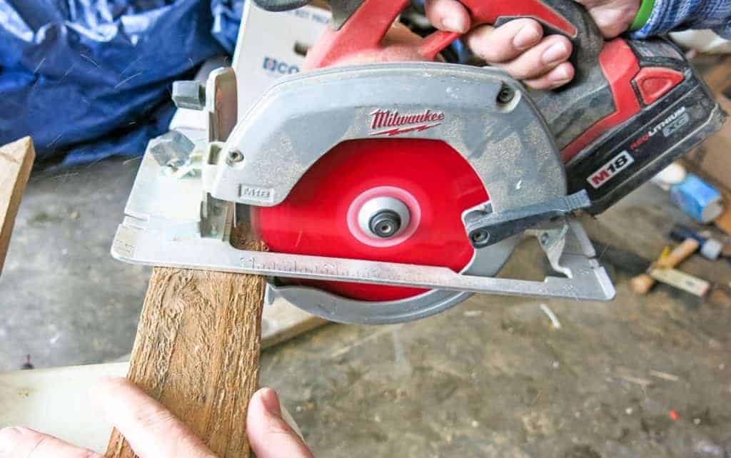 shows a Milwaukee circular saw cutting a piece of pallet wood