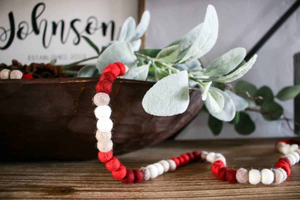 This felt balls string for Valentine's Day decorations is perfect pouring out of the wooden dough bowl