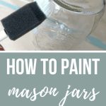 Painting mason jar with text overlay that says How to Paint Mason Jars on the Cheap