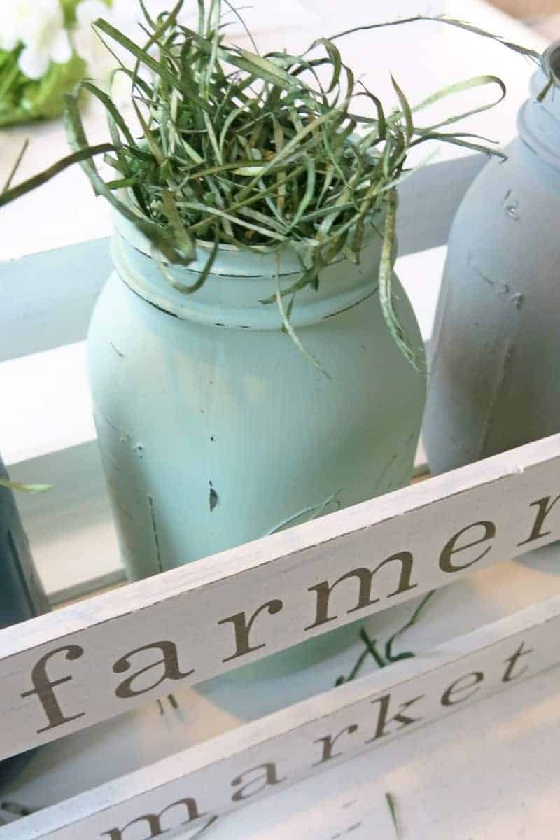 A painted mason jar stuffed with grass makes a perfect Easter center piece