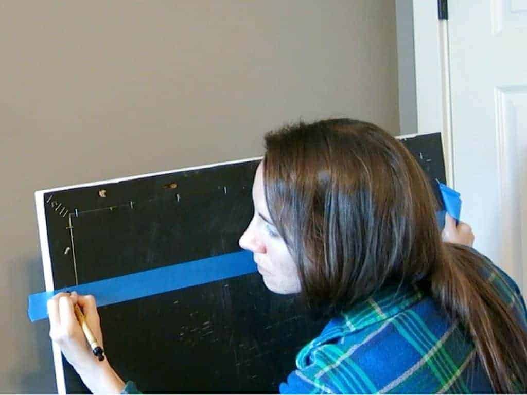 Use a pen, pencil, or permanent marker to mark where the keyhole is on the painters tape, which will help you to easily hang the picture frame.