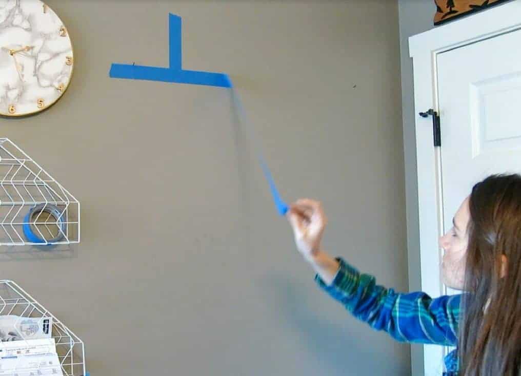 After the nails are hammered into the wall, remove the painters tape guide, leaving only the nails on the wall.