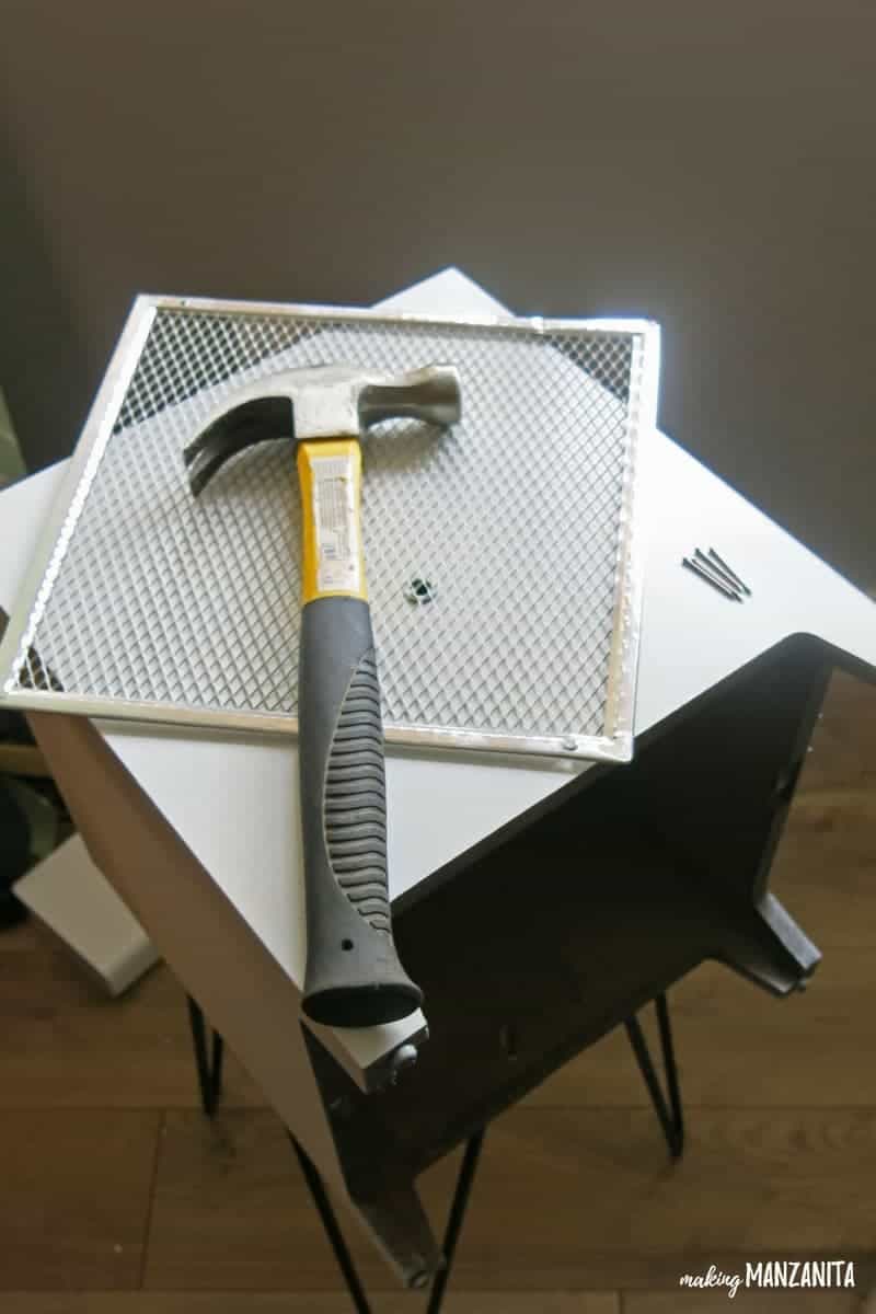 I repurposed this metal grate to make a shelf for the modem and router storage box. To create the shelf, I needed a hammer and nails.