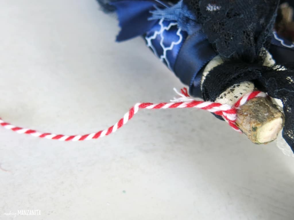 Use red and white thread to create a tie to hang your American flag window hanging.