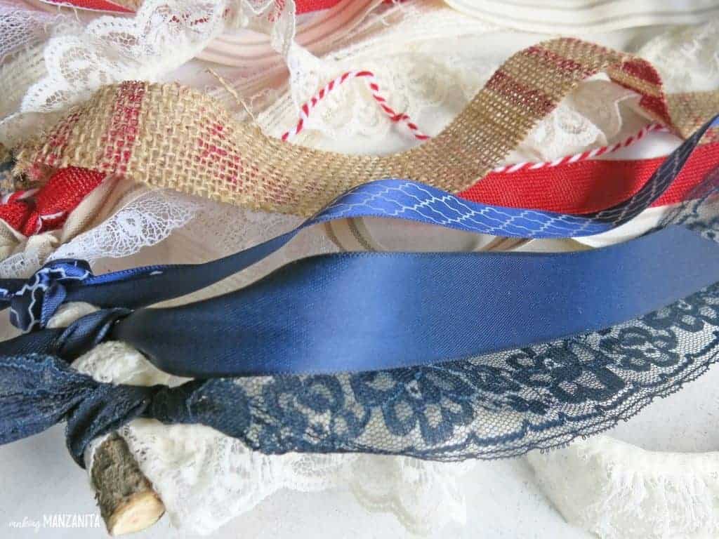 Strips of red, white, and blue fabric to create a DIY ribbon flag window hanging