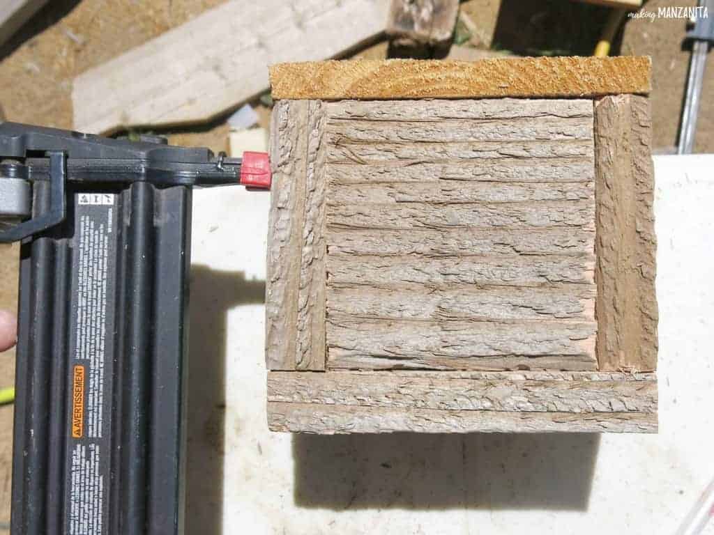 Bottle of reclaimed wood DIY bottle opener getting nailed together to secure