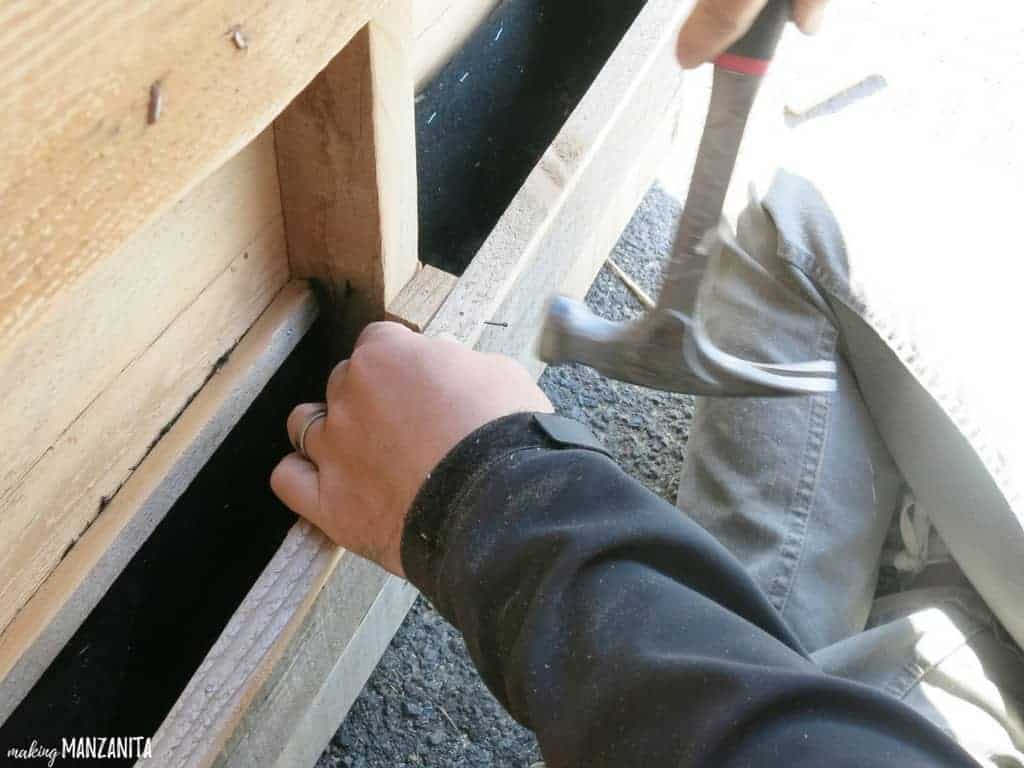 Adding trim to the wood pallet; these wood pieces will cover up the staples from the landscaping fabric, making the vertical pallet garden look aesthetically cleaner