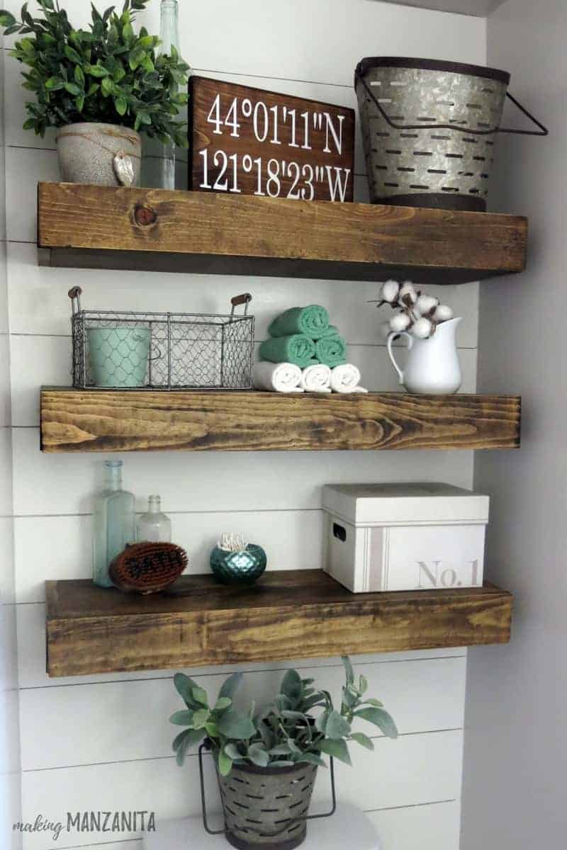 The floating shelves above the toilet in the farmhouse master bathroom are decorated with trinkets--my favorite of which is the wood coordinates sign I had made on Etsy.