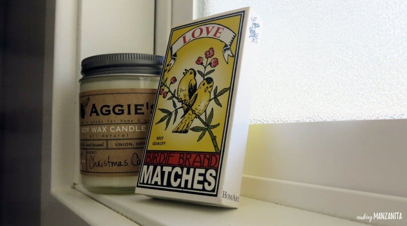 A box of matches in a decorative box next to a soy wax candle sits on the window sill in our farmhouse style master bathroom.