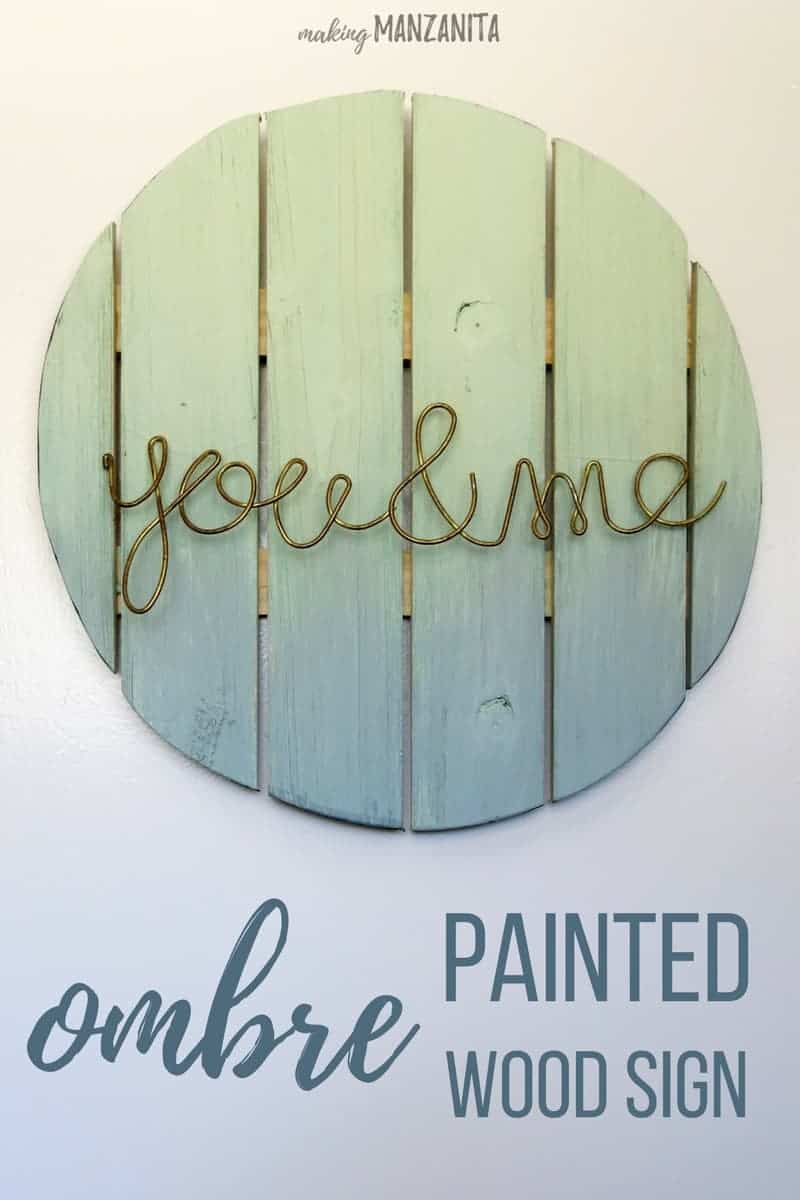 A ombre painted wood sign with metal letters hanging on a white wall, with text overlay that reads 