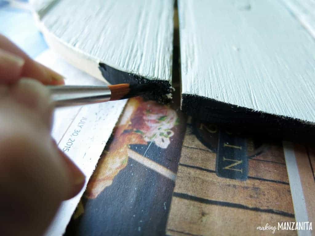 Painting the edges of the ombre wood sign with black acrylic paint.