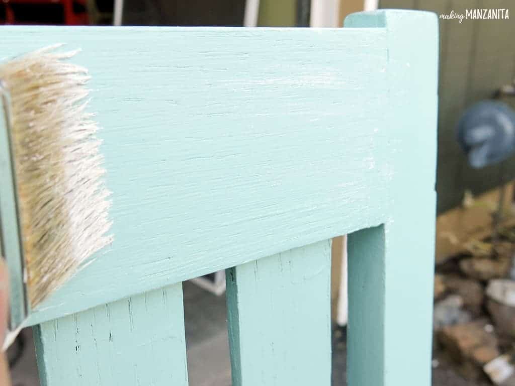 Using a paint brush to apply the second coat of Sherwin Williams Resilience Acrylic Latex Exterior Paint in the color Refresh - a gorgeous light teal green