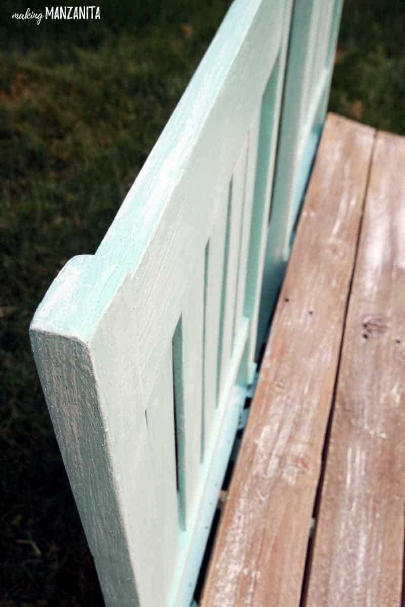 A closer look at the dry brushed white paint on the back of the upcycled bench. Dry brushed white paint gives the bench a vintage, weather-worn effect.