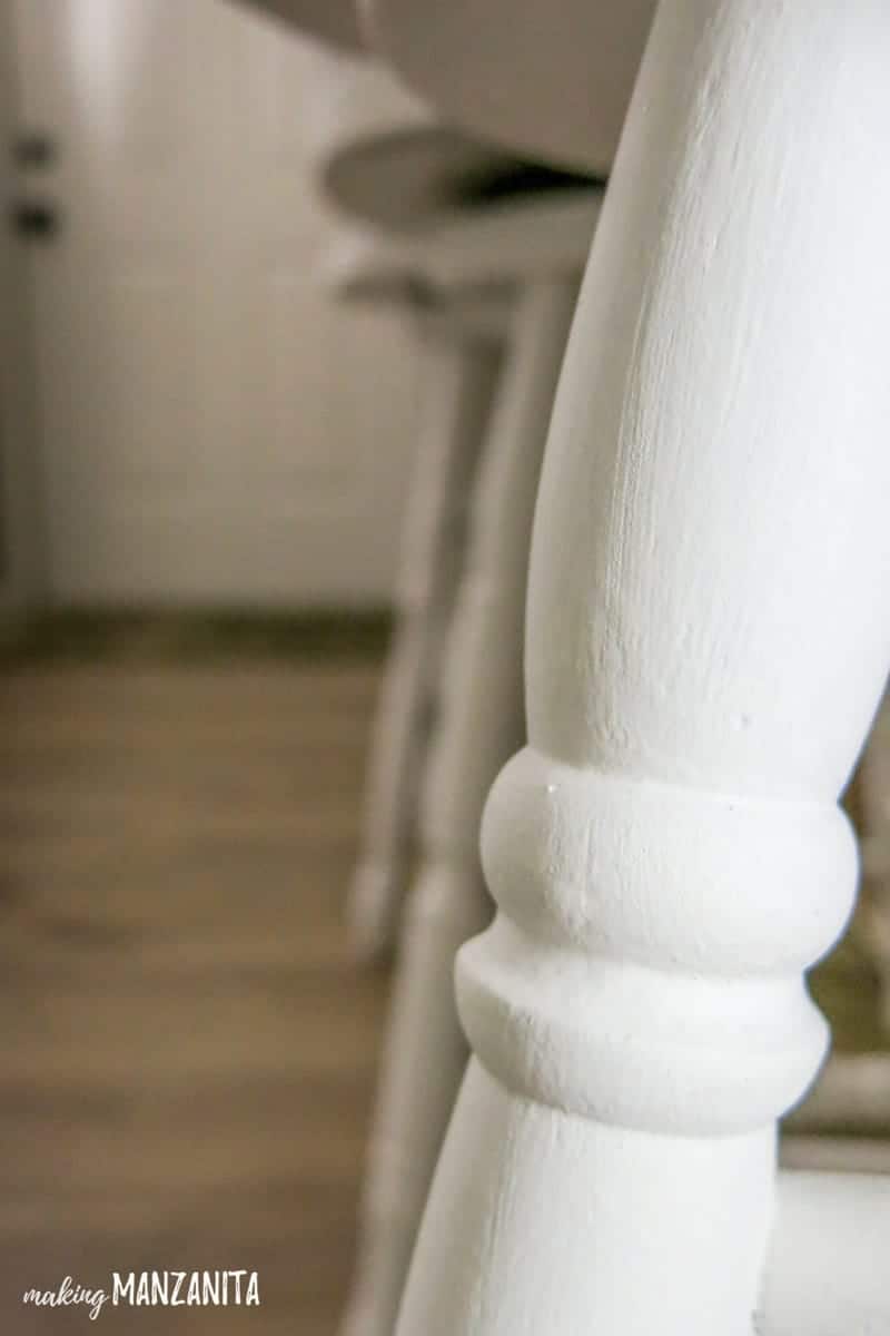 A close up look at the legs of a chalk paint bar stool, painted with General Finishes white chalk paint.