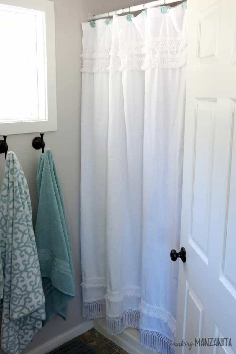 A look at the finished product - a white macramé shower curtain lengthened to the right length with fringe fabric.