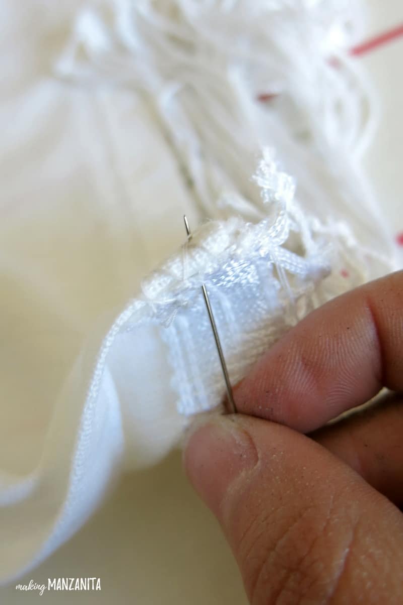 Use a needle and thread to secure the adhesive tape to the fabric trim.