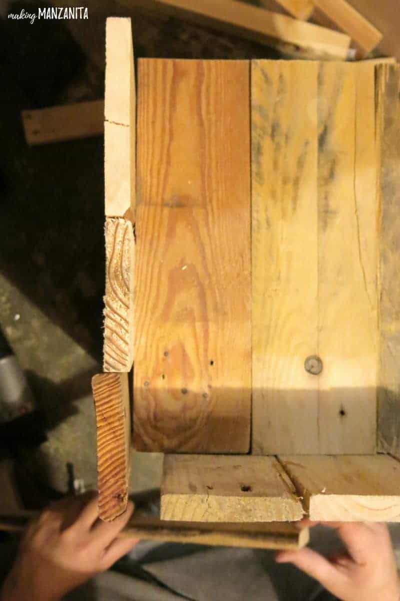 Planks of pallet wood stacked together in the process of building a DIY pallet wood side table.