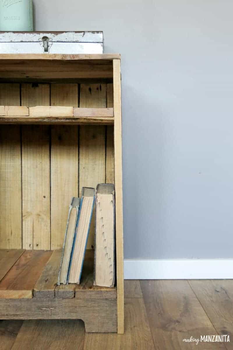 Vintage books sit on the lower shelf of the DIY rustic pallet wood side table.