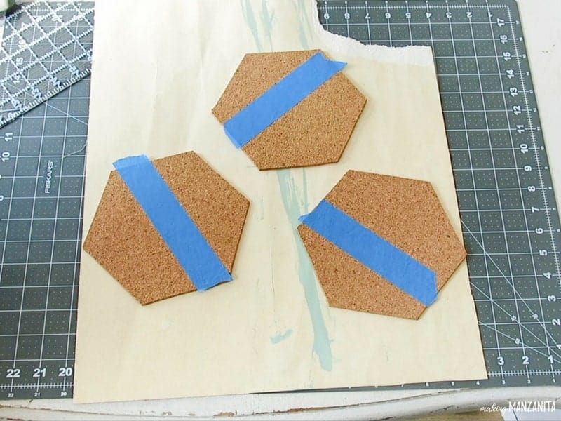 Hexagon cork boards with painter's tape taped off the top to color block paint the cork